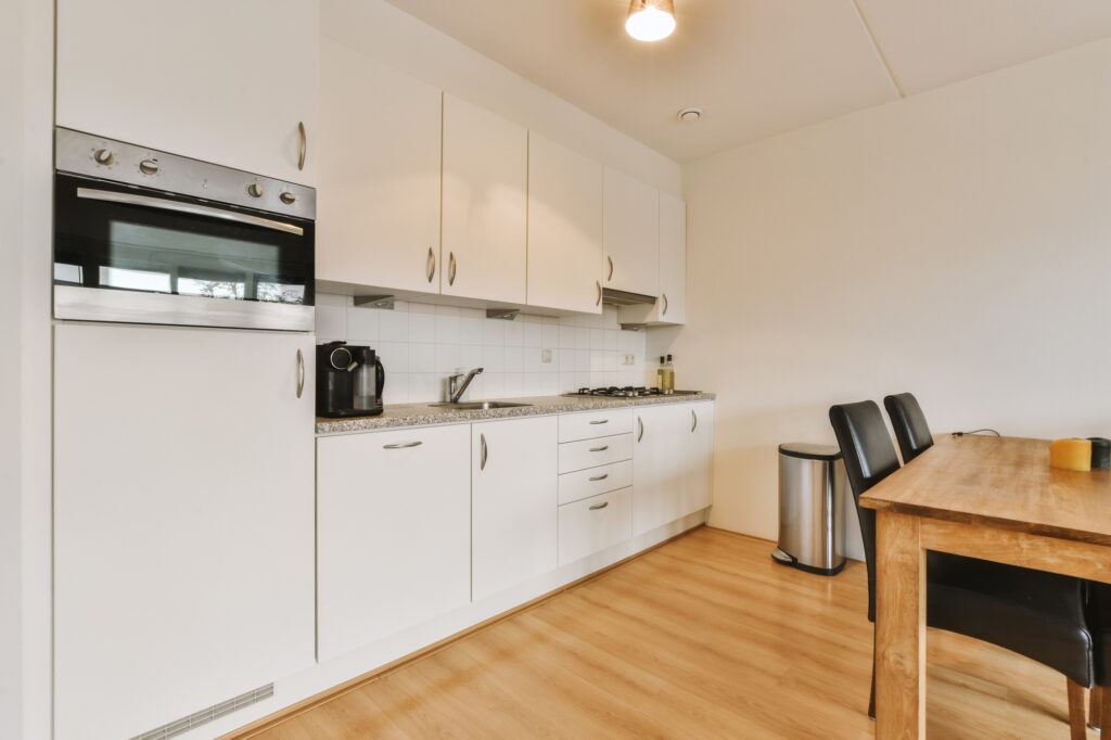 a kitchen with white cabinetry and a wooden table